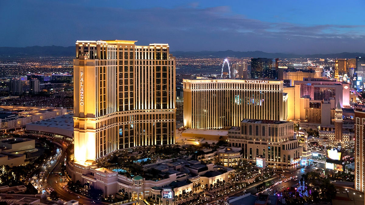 Nighttime view of Las Vegas with cars and buildings, highlighting the golden-lit Venetian Resort, a case study of Apollo’s private equity investment.